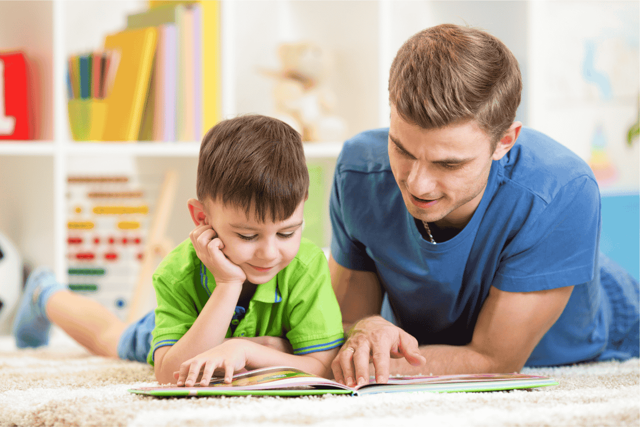 Sprachförderung bei Kindern im Familienalltag - Vater liest gemeinsam mit Sohn ein Buch